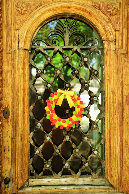 오래된 나무 문에 매달려 있는 아름다운 사탕 화환