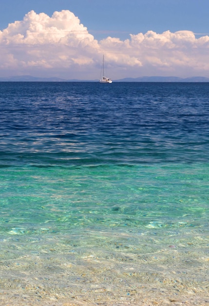 ギリシャのイオニア海のケファロニア島の背景に美しいヨットと女性