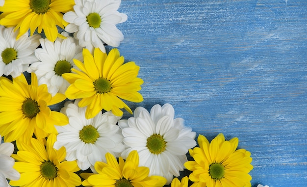 Foto bellissimi fiori gialli e bianchi su un tavolo di legno