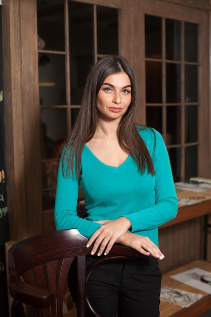 Beautiful young adult woman and chair in living room