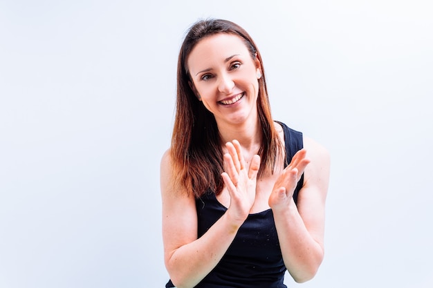 Beautiful young adult woman clapping hands with white background. congratulate concept