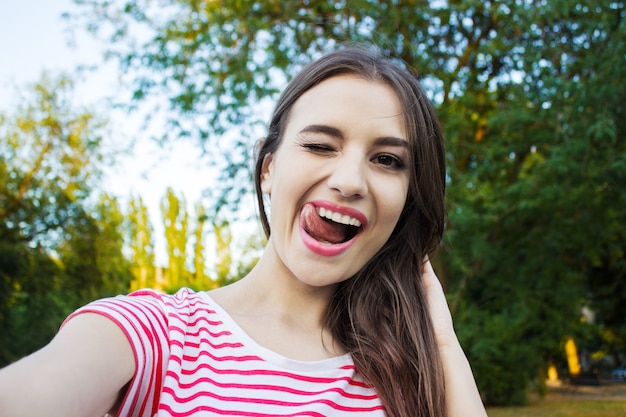 Beautiful young adult woman taking picture of herself, selfie