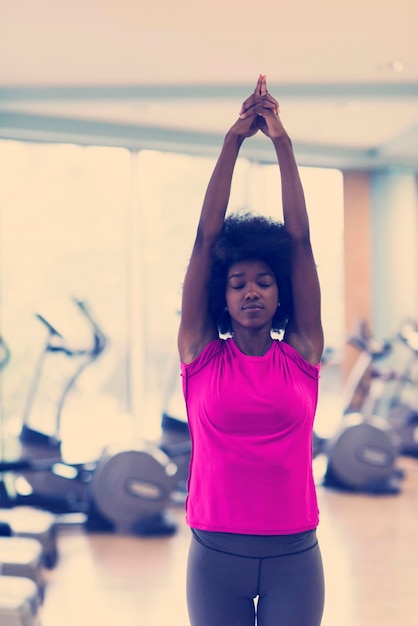 Beautiful young african american woman exercise yoga in\
gym