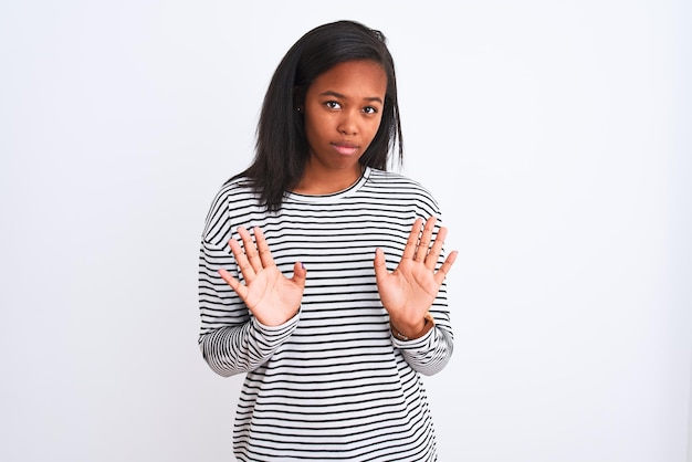 Beautiful young african american woman wearing winter sweater over isolated background Moving away hands palms showing refusal and denial with afraid and disgusting expression Stop and forbidden