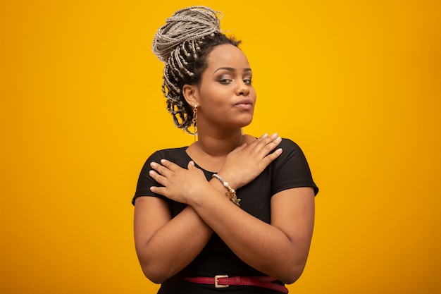 Beautiful young african american woman with dread hair on yellow