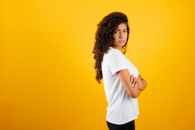 Beautiful young african black girl isolated over yellow