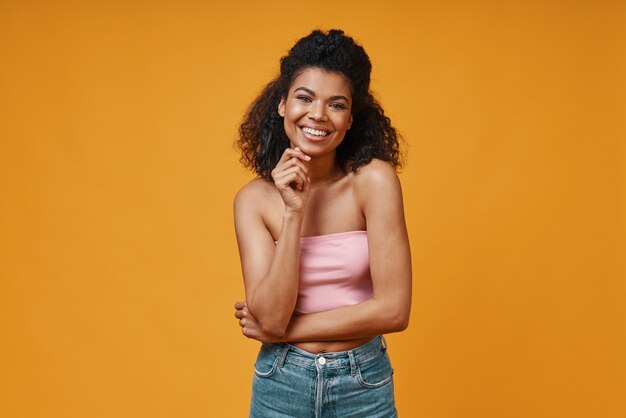 Beautiful young African woman in casual clothing looking at camera and smiling