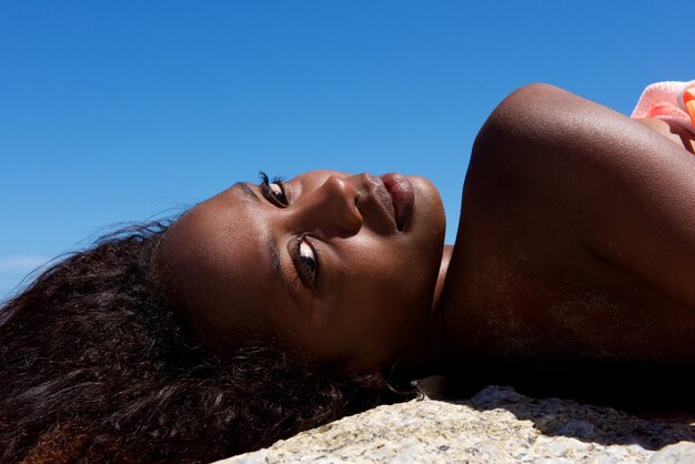 Photo beautiful young african woman lying outdoors