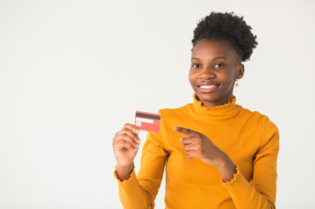 手でクレジットカードを持つ美しい若いアフリカ人女性