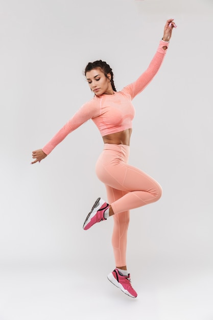 a beautiful young amazing strong sports fitness woman posing isolated over white wall background.