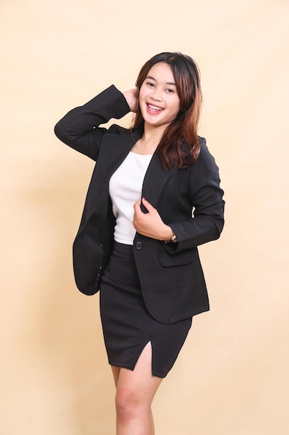 Beautiful young Asian executive woman standing happily and looking at you holding suit half body por