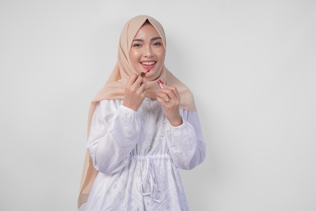 Красивая молодая азиатская мусульманка в белом платье и хиджабе, макияж, помада, мода и косметика, концепция красоты.