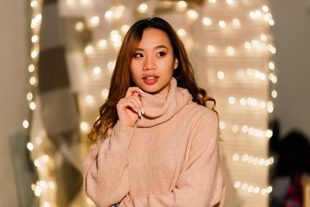 Beautiful young asian woman celebrating christmas at home, having fun while opening presents