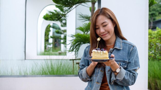 A beautiful young asian woman eating blueberry cheesecake