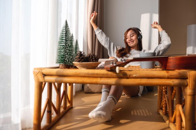 Photo a beautiful young asian woman enjoy listening to music with headphone at home