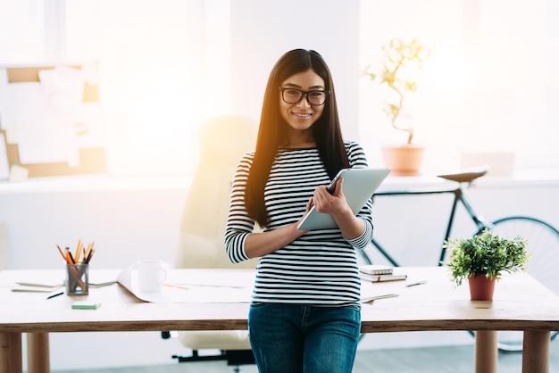 beautiful young Asian woman in glasses holding digital tablet