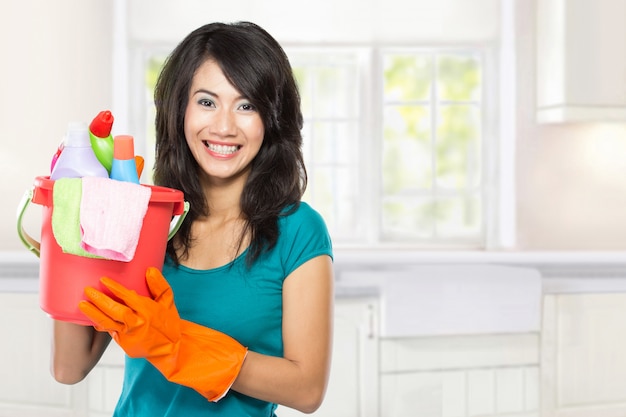 Beautiful young asian woman holding a basket full of cleaning products