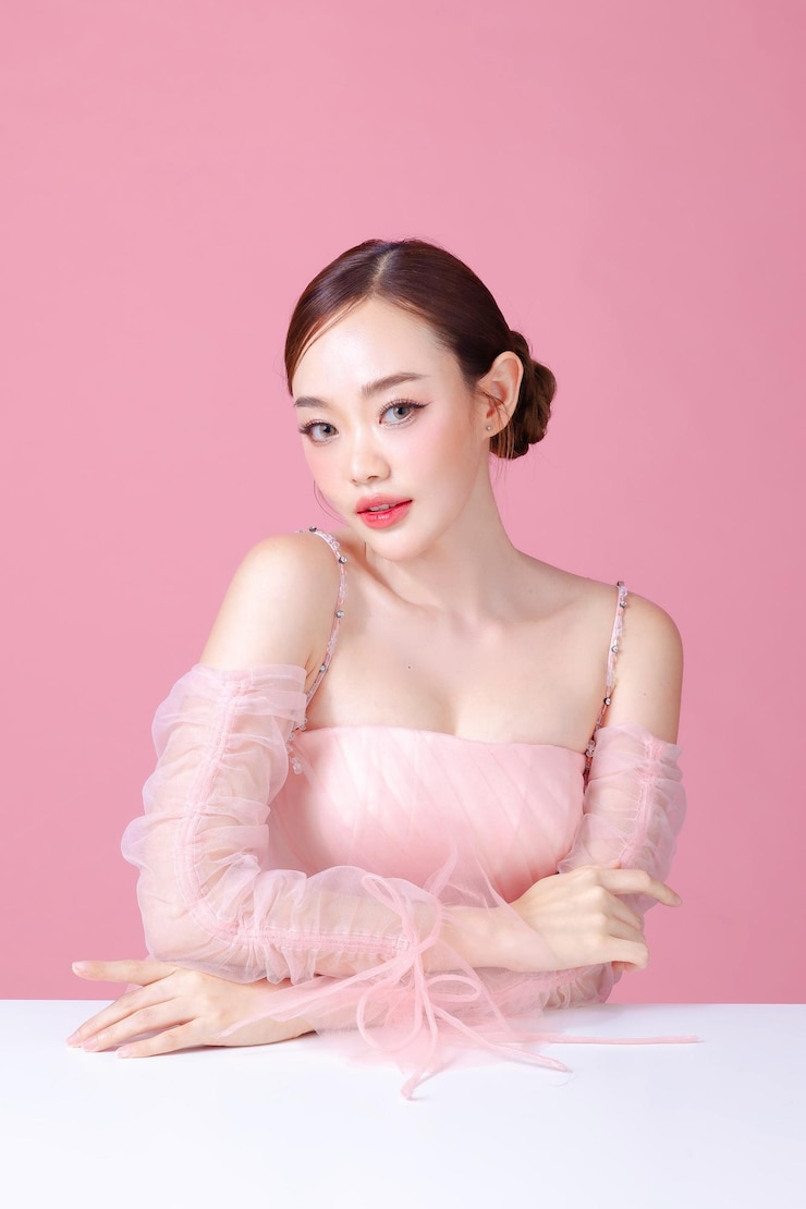 美麗的年輕亞洲女性模特兒, 臉上有天然化<unk>的毛髮, 面部有乾淨的新鮮皮膚, 隔離的粉紅色背景, 可愛的女孩肖像, 面部治療, 情人節概念