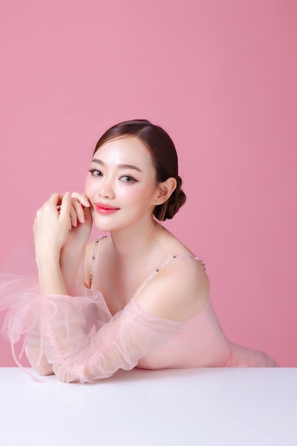 사진 아름다운 젊은 아시아 여성 모델 털과 자연 메이크업 얼굴에 고립 된 분홍색 배경에 깨한 신선한 피부 귀여운 소녀 초상화 얼굴 치료 발렌타인 개념
