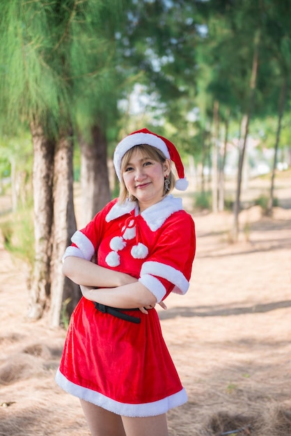 Beautiful young asian woman in Santa Claus clothes outdoors