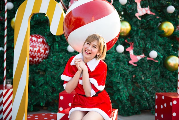 Красивая молодая азиатка в одежде Санта-Клауса на открытом воздухеТаиландцыПослали счастье для детейСчастливого РождестваДобро пожаловать в зимуУкрашенный рождественский фон