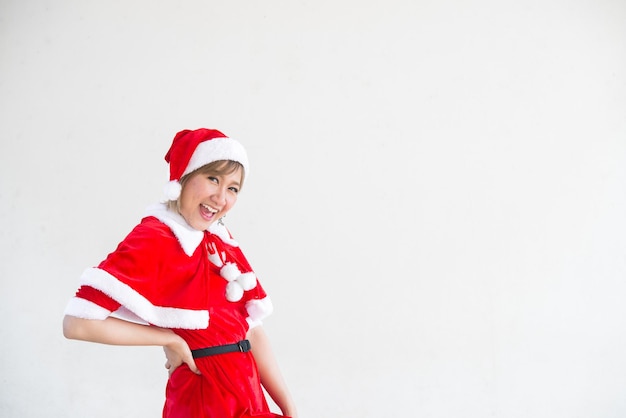 白い背景の上のサンタクロースの服を着た美しい若いアジアの女性タイの人々子供たちに幸せを送ったメリークリスマス冬へようこそ幸せな女性のコンセプト