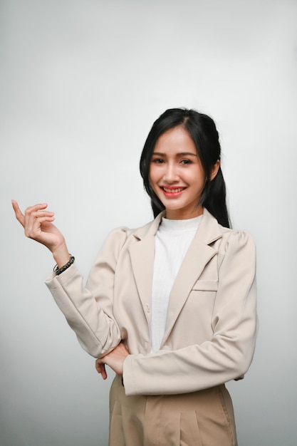 Bella giovane donna asiatica sorridente e in piedi isolato su sfondo grigio studio