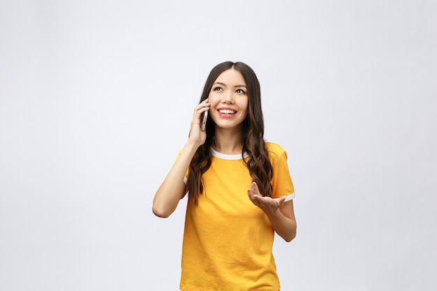 Мобильный телефон красивой молодой азиатской женщины говоря и улыбка