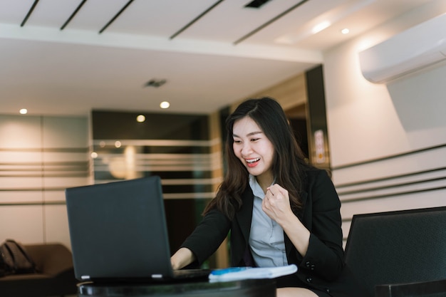 Beautiful young Asian woman using her laptop