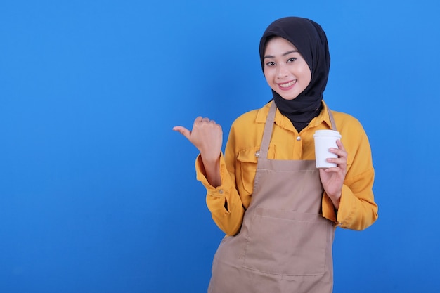 Beautiful young asian woman wear apron holding a glass of coffee