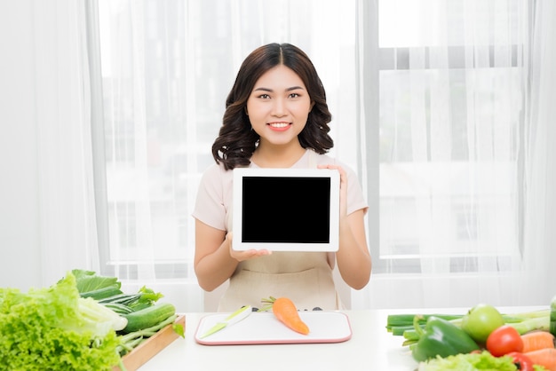 태블릿 컴퓨터 화면을 보여주는 아름다운 젊은 아시아 여성