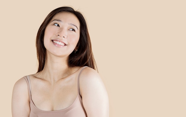 Beautiful young Asian woman with clean fresh skin on beige background, face care, facial treatment, cosmetology, beauty and spa, Asian women portrait.