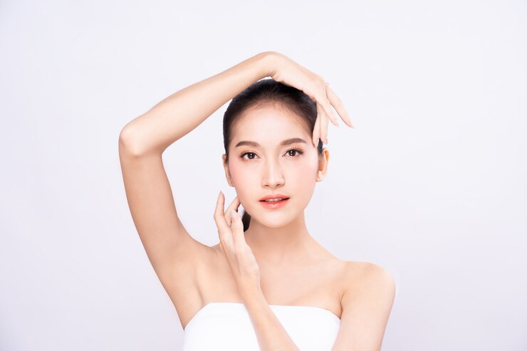 美容ポーズで顔に2つの手に触れる清潔で新鮮な肌と美しい若いアジア女性。