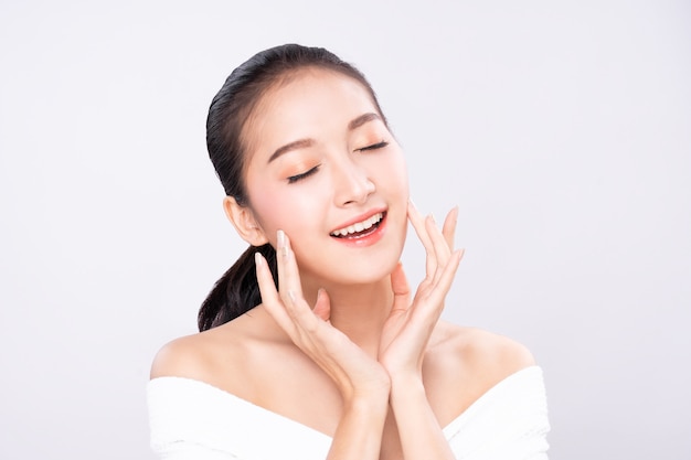 Photo beautiful young asian woman with clean fresh white skin face in beauty pose touching shoulder with finger.