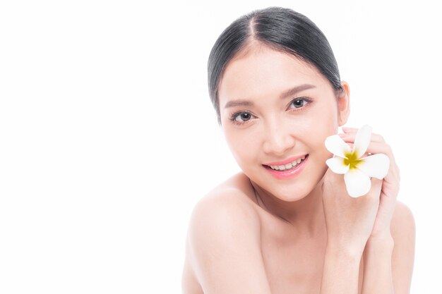 Beautiful young Asian woman  with clean skin ,Fresh skin holding  white flower tropical leaf in hands on white background - Beauty shot of Asian woman Facial treatment , Cosmetology , beauty and spa