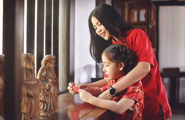 Beautiful young Asian woman with a girl are celebrate Lunar new year in the house