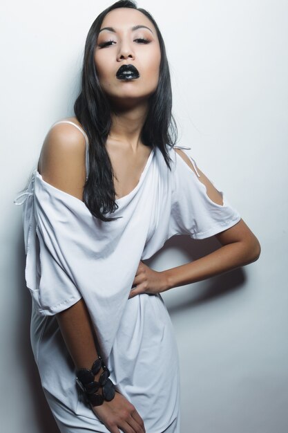 Beautiful young asian woman with perfect skin and black  lipstick, fashion shoot