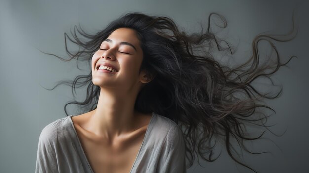 아름다운 젊은 아시아 여성들이 빈 어두운 회색 배경에 대한 초상화에서 기게 웃고 있습니다.