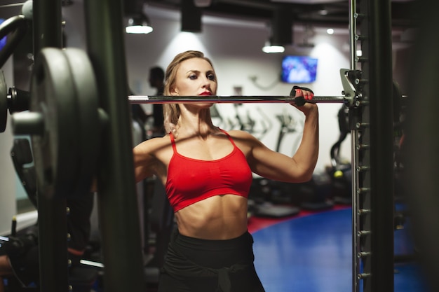 Beautiful young athletic woman is training in the gym