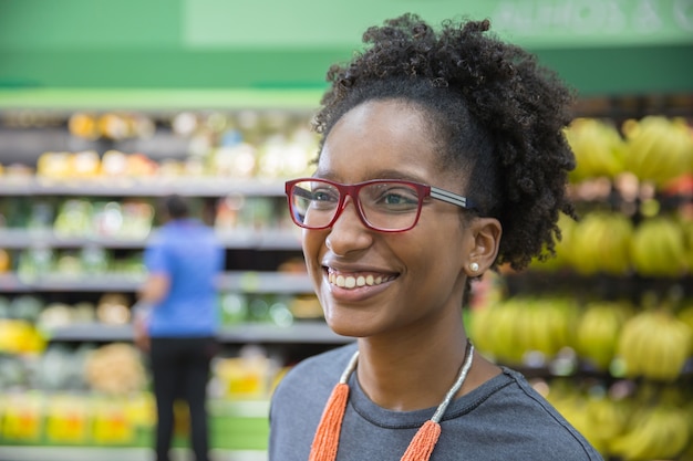 Beautiful young black woman smiling in a supermarket