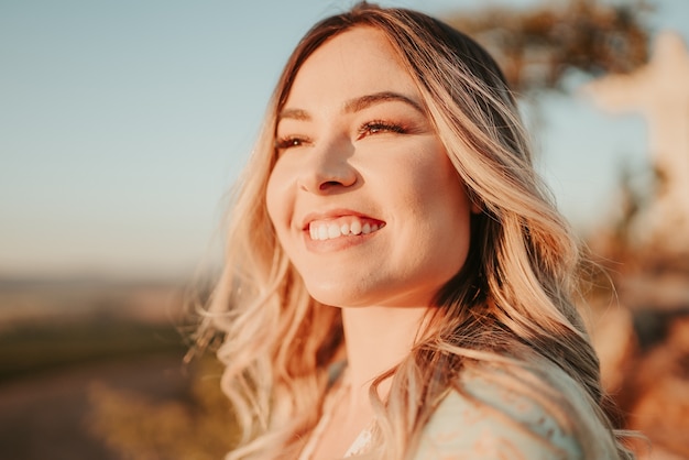 Beautiful young blond Latin woman outdoors portrait. Hair develop on a wind. Fashion concept.