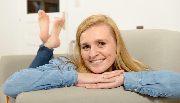 Beautiful young blonde woman relaxing on sofa