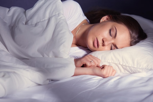 Bella giovane donna bionda che dorme nel letto