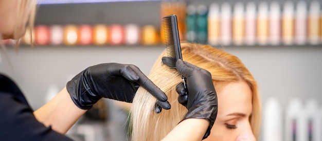 Photo beautiful young blonde woman with long straight blonde hair getting a haircut at the hairdresser salon