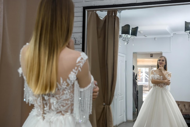 Beautiful young bride posing in wedding dress in salon