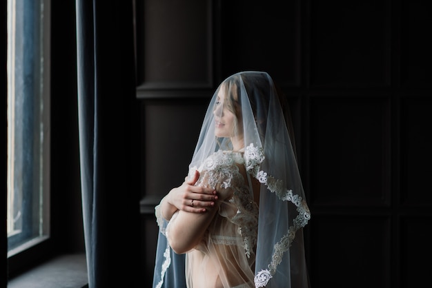 Beautiful young bride in a white lingerie. Last preparations for the wedding waiting for the groom.