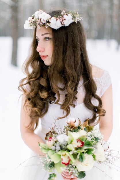 Beautiful young bride in the winter snowy forest