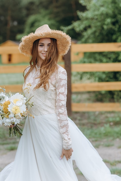 A beautiful young bride with a bouquet of daisies in a field