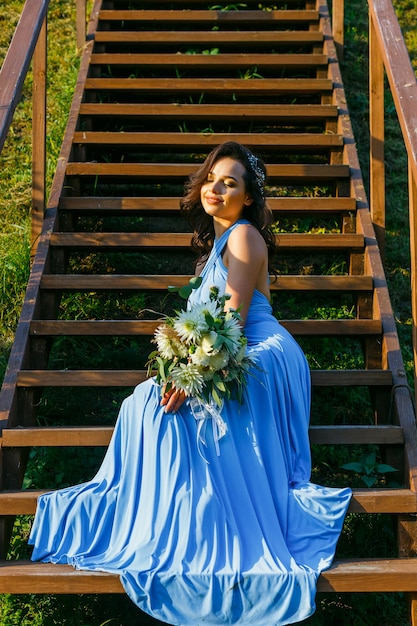 Beautiful young bridesmaid with curly hair posing on wedding ceremony