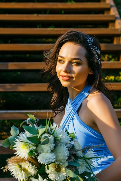 Beautiful young bridesmaid with curly hair posing on wedding ceremony